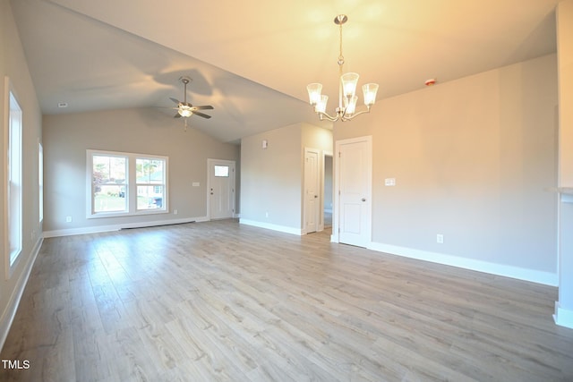 empty room featuring ceiling fan with notable chandelier, light hardwood / wood-style flooring, a baseboard radiator, and lofted ceiling