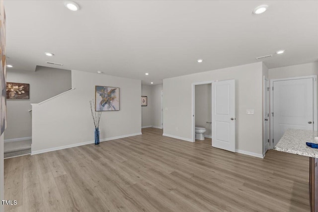 unfurnished living room with recessed lighting, light wood-type flooring, visible vents, and baseboards