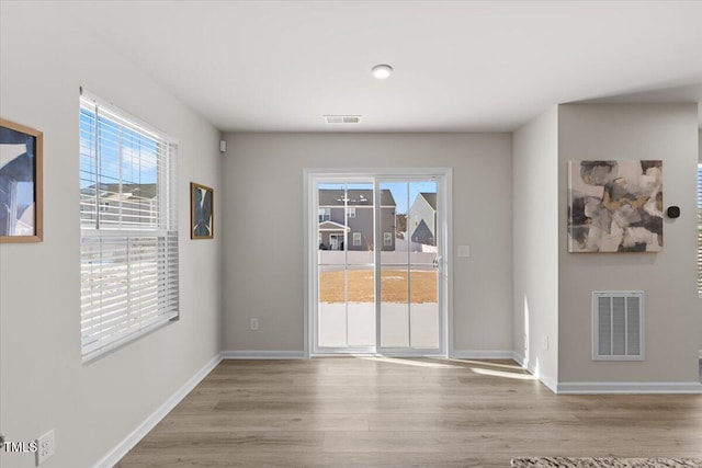 unfurnished dining area with light wood-style floors, baseboards, and visible vents