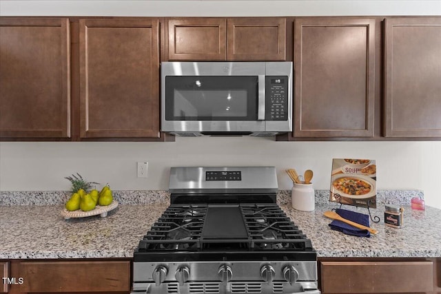 kitchen featuring light stone countertops and stainless steel appliances