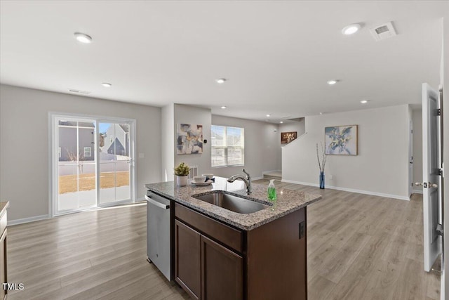 kitchen featuring a sink, open floor plan, dark brown cabinets, light stone countertops, and dishwasher