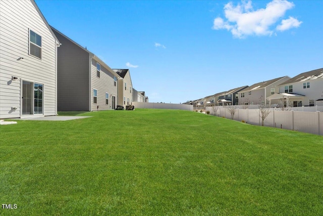 view of yard with a fenced backyard and a residential view