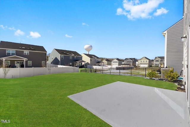 view of yard featuring a fenced backyard, a residential view, and a patio