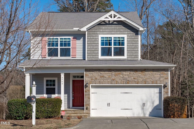 view of front of property with a garage, stone siding, driveway, and a porch