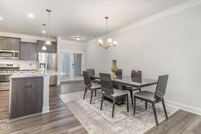 dining room featuring crown molding, recessed lighting, an inviting chandelier, dark wood-type flooring, and baseboards