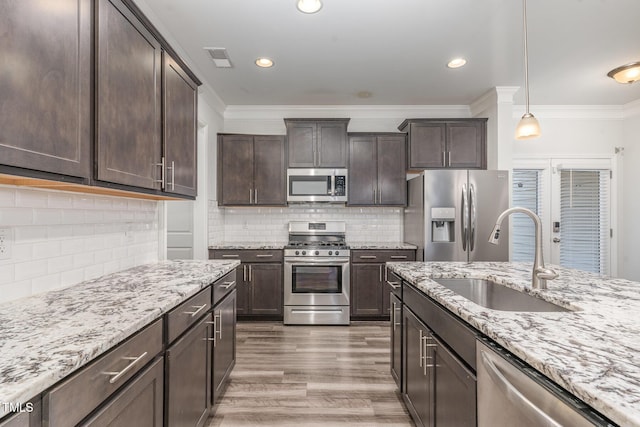 kitchen featuring appliances with stainless steel finishes, a sink, and dark brown cabinetry