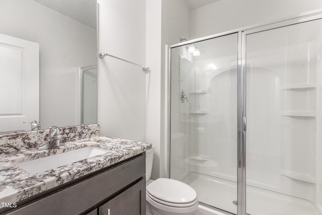 bathroom featuring a stall shower, vanity, and toilet