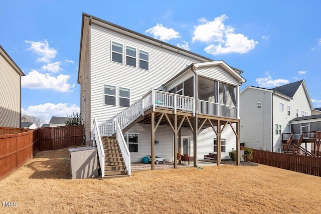 back of property featuring a sunroom, a fenced backyard, a patio area, and stairway