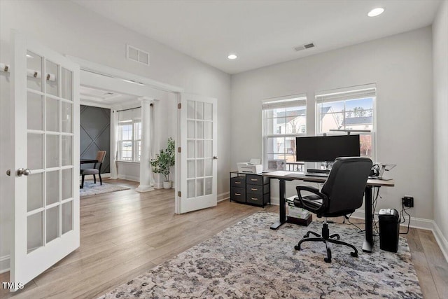 office featuring light wood-style flooring, visible vents, baseboards, and french doors