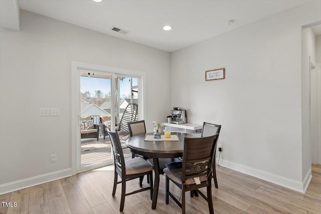 dining room featuring light wood-type flooring, baseboards, and visible vents