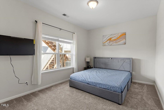 bedroom with carpet floors, visible vents, and baseboards