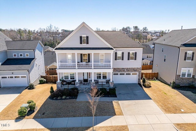 view of front of home featuring a porch, a balcony, fence, driveway, and a front yard