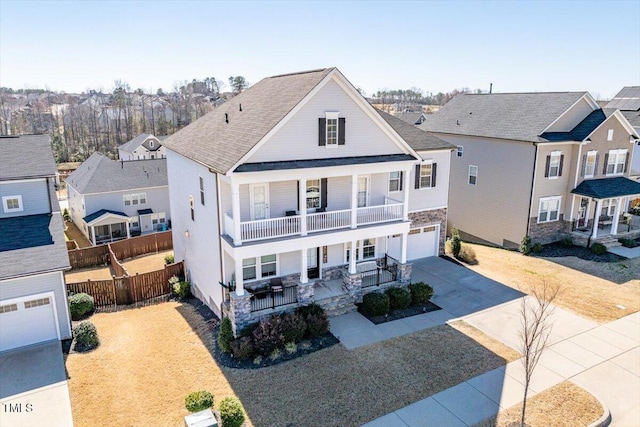 view of front of property with an attached garage, covered porch, fence, concrete driveway, and a residential view