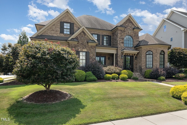 view of front of home with brick siding and a front lawn