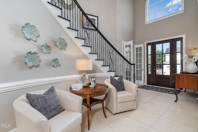 tiled foyer with stairway and a high ceiling