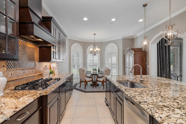 kitchen with crown molding, appliances with stainless steel finishes, an inviting chandelier, light tile patterned flooring, and a sink