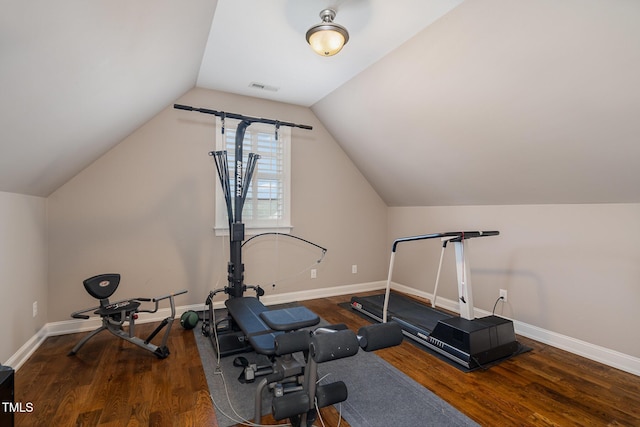 exercise area featuring visible vents, baseboards, lofted ceiling, and wood finished floors