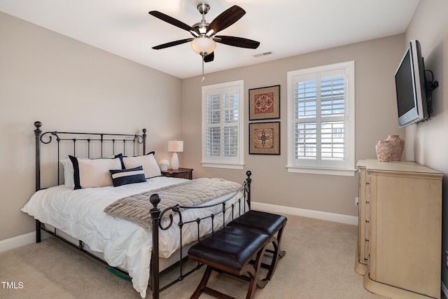 bedroom featuring light carpet, visible vents, a ceiling fan, and baseboards