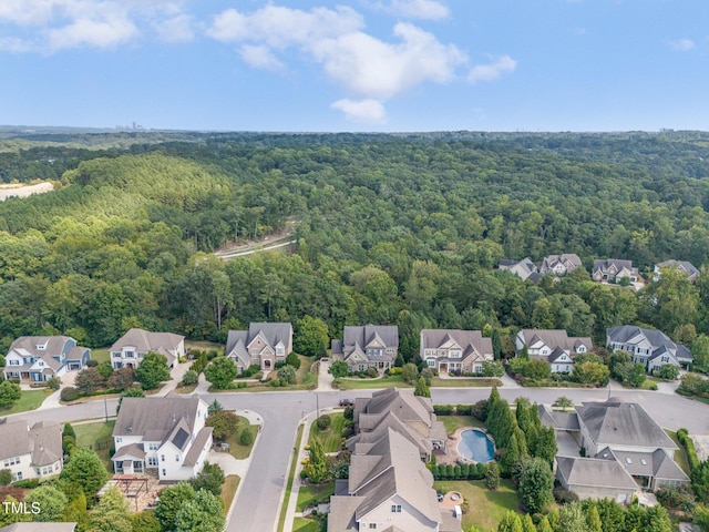 birds eye view of property featuring a residential view and a wooded view