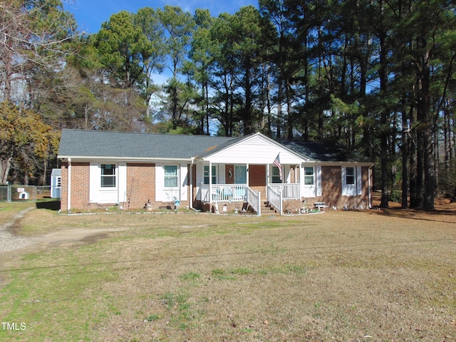 ranch-style home featuring a porch and a front lawn