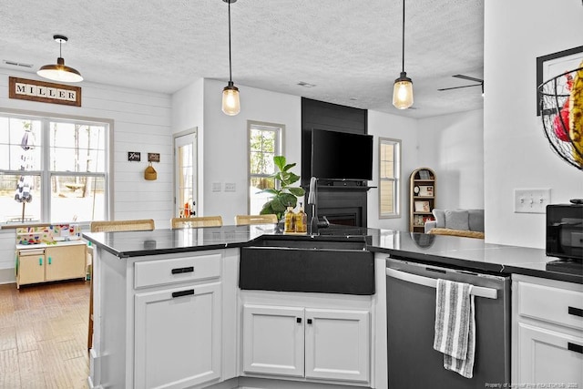 kitchen featuring sink, white cabinetry, decorative light fixtures, dishwasher, and kitchen peninsula