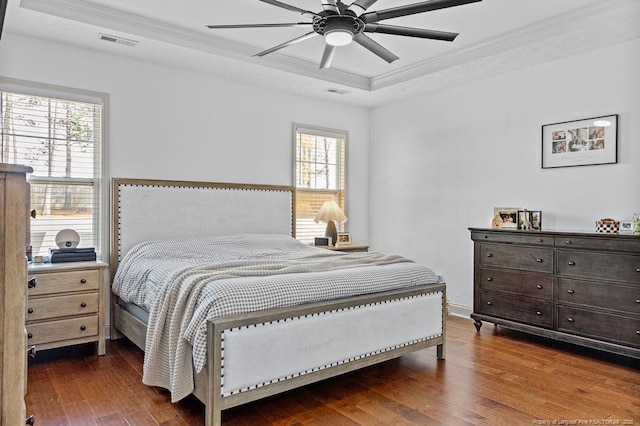 bedroom with a raised ceiling, ornamental molding, hardwood / wood-style floors, and ceiling fan