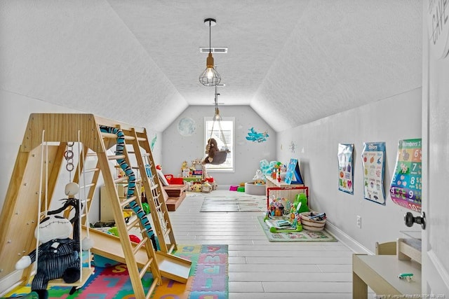 game room featuring hardwood / wood-style flooring, lofted ceiling, and a textured ceiling