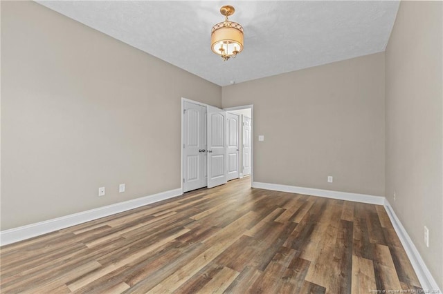 empty room with dark hardwood / wood-style flooring