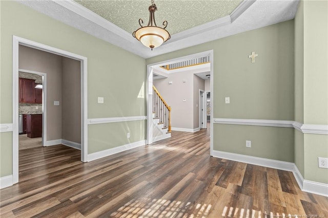 spare room with dark hardwood / wood-style floors, a raised ceiling, and a textured ceiling