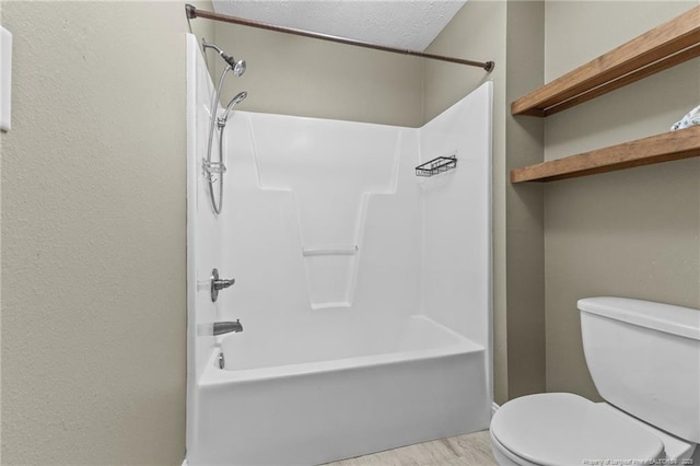 bathroom featuring a textured ceiling, wood-type flooring, and toilet