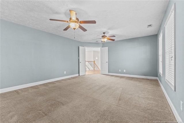 spare room featuring ceiling fan, a textured ceiling, and carpet flooring