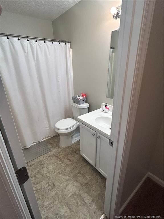 bathroom featuring vanity, a textured ceiling, and toilet