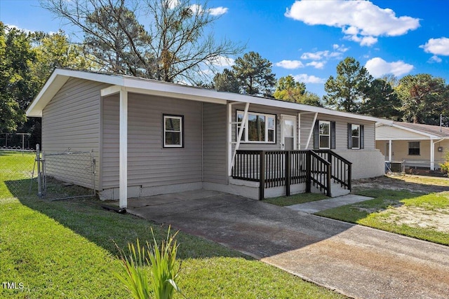 manufactured / mobile home featuring a carport and a front yard