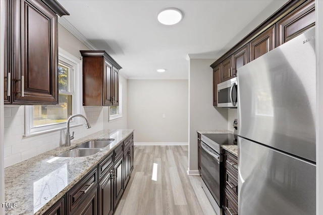 kitchen featuring dark brown cabinetry, sink, crown molding, tasteful backsplash, and stainless steel appliances