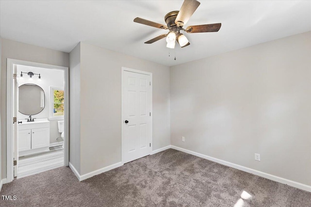 unfurnished bedroom featuring ensuite bathroom, carpet flooring, and ceiling fan