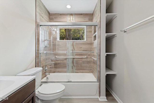 full bathroom featuring toilet, vanity, and shower / bath combination with glass door