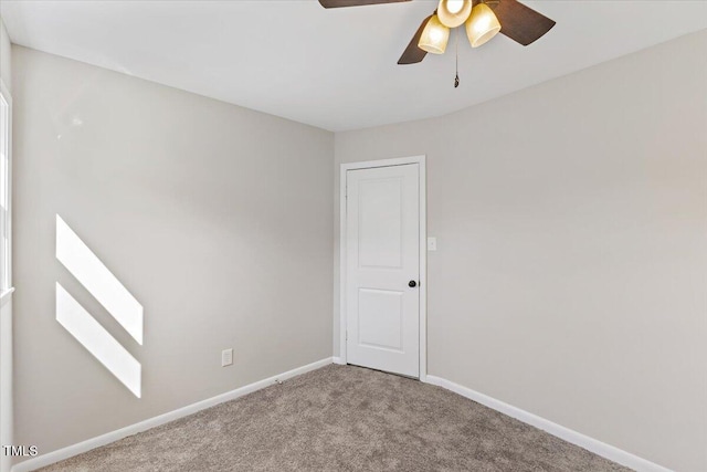 empty room featuring ceiling fan and carpet