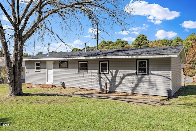 rear view of house featuring a lawn