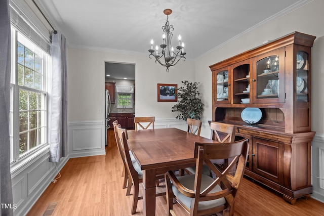 dining space featuring light wood-style floors, a wealth of natural light, and visible vents