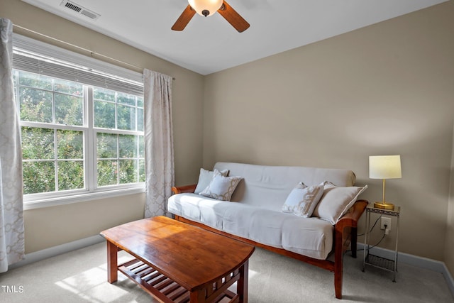 carpeted living room with baseboards, visible vents, and ceiling fan