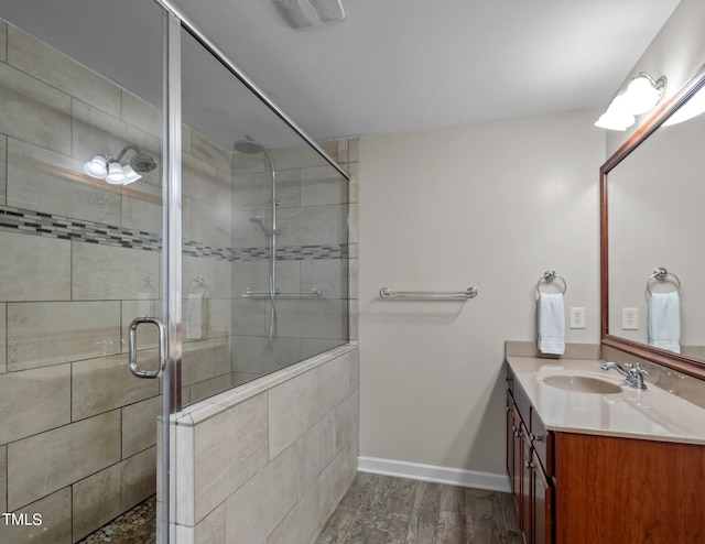 bathroom featuring visible vents, a stall shower, vanity, wood finished floors, and baseboards