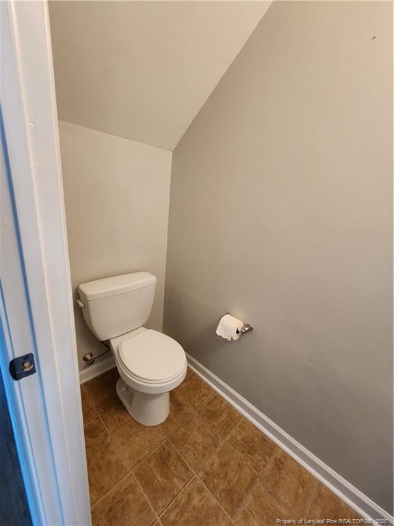 bathroom featuring tile patterned floors, toilet, and vaulted ceiling