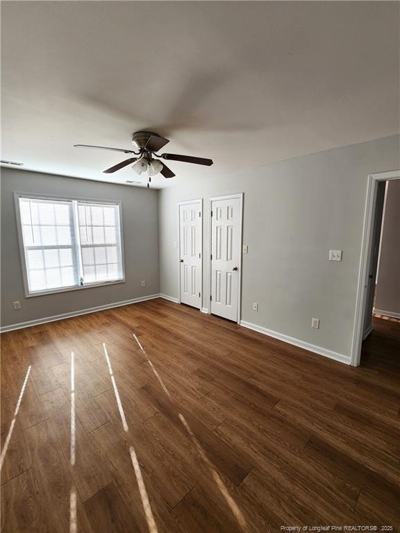 spare room with ceiling fan and dark hardwood / wood-style floors