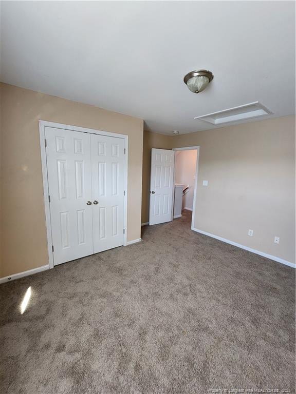 unfurnished bedroom with carpet flooring and a closet