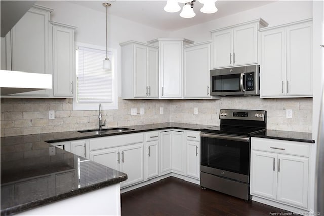 kitchen with hanging light fixtures, sink, white cabinets, and appliances with stainless steel finishes