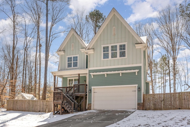 view of front of property with concrete driveway, stairway, fence, a porch, and board and batten siding