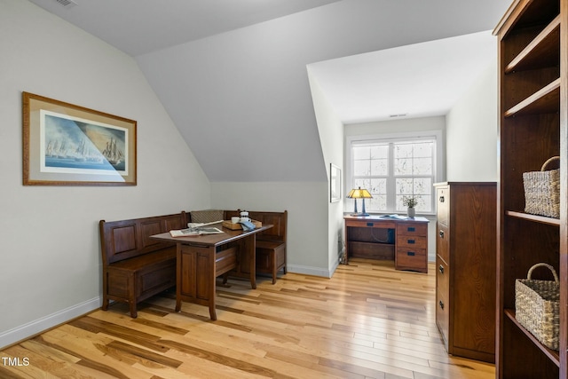 office with lofted ceiling, baseboards, and light wood-style floors