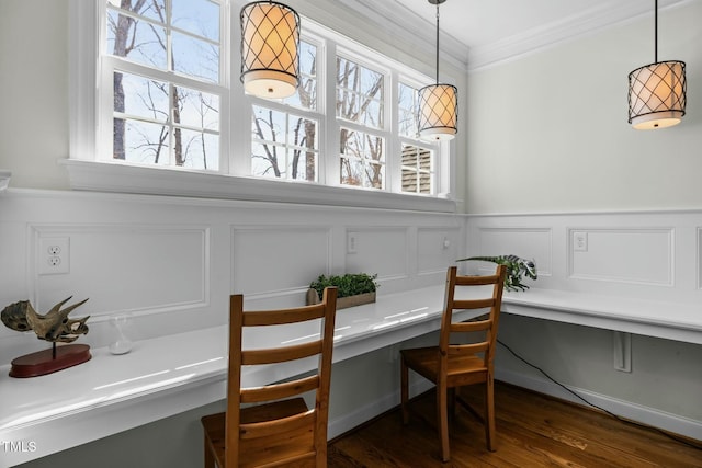 dining space featuring ornamental molding, built in desk, dark wood-style flooring, and plenty of natural light