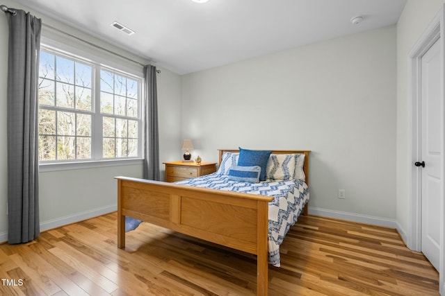 bedroom featuring light wood-type flooring, baseboards, and visible vents