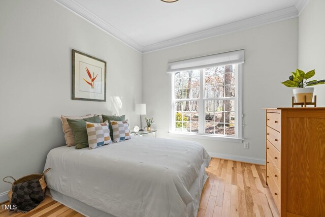 bedroom with baseboards, light wood-style flooring, and crown molding